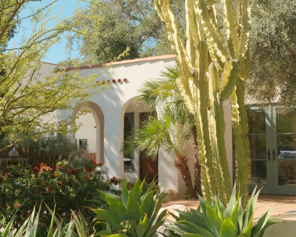 Spanish-style home with a stucco arch and a garden of drought-tolerant plants